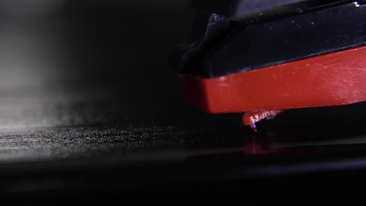 A macro shot of a needle being placed on a still record-vinyl and then turned on to spin