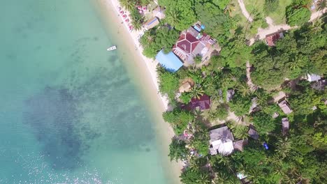 aerial down vertical shot of a tourist beach on koh chang with jungle and sea and bungalow resorts