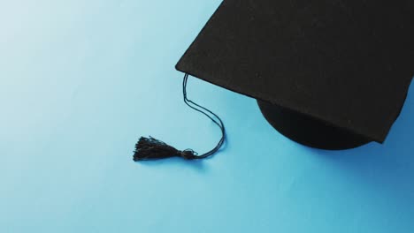 Video-of-graduation-hat-lying-on-blue-background