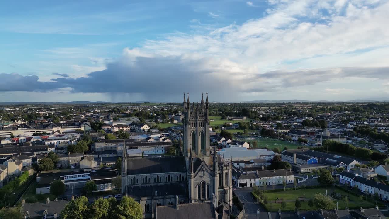 Vista aerea con drone della Cattedrale di St Mary a Kilkenny, con un'alta torre gotica che domina la città storica, i tetti, le strade e un ampio cielo blu con nuvole sparse