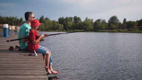 father and son fishing on a lake pier