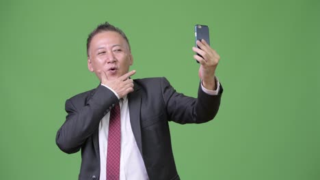 성숙한 일본 사업가 전화를 사용