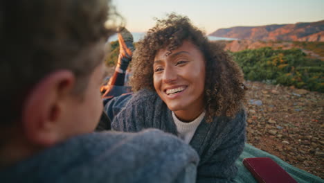 happy sweethearts relaxing evening beach closeup. curly woman lying on blanket