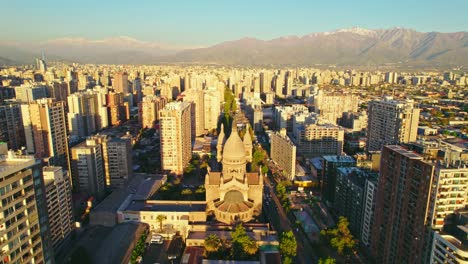 Aerial-dolly-towards-Sacramentinos-church-and-the-Santiago-Centro-skyline