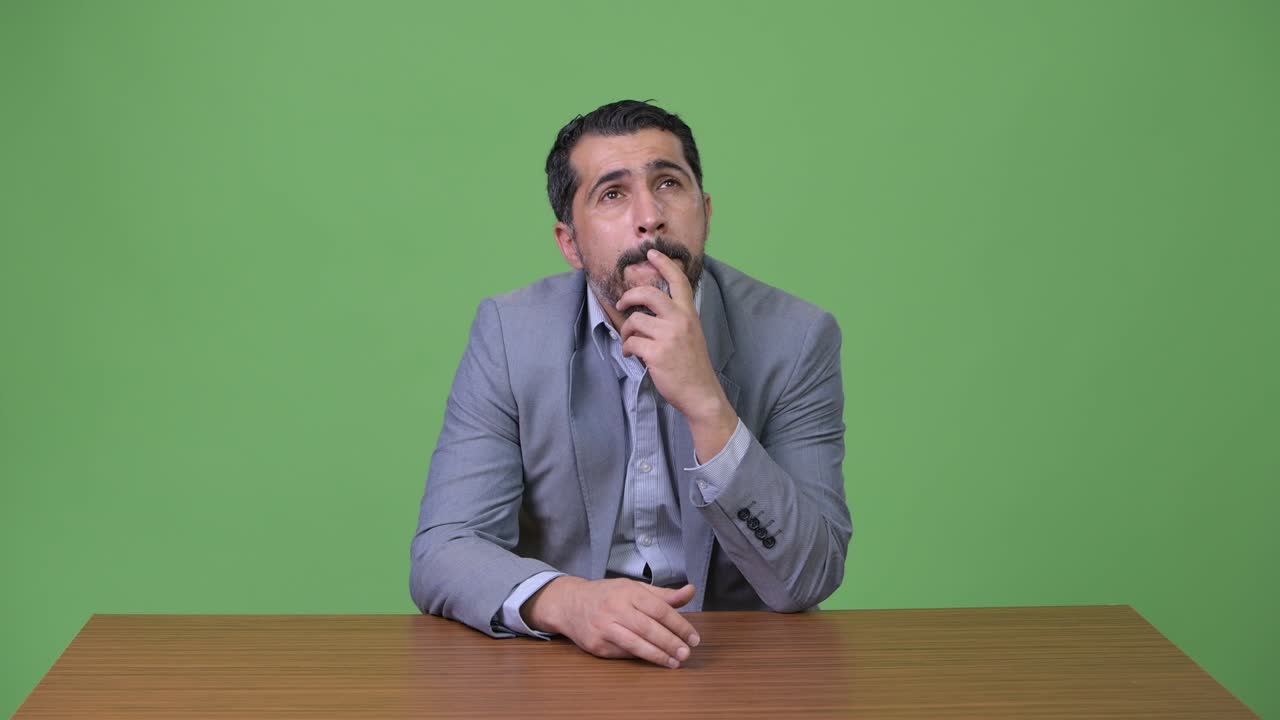 Handsome Persian bearded businessman thinking