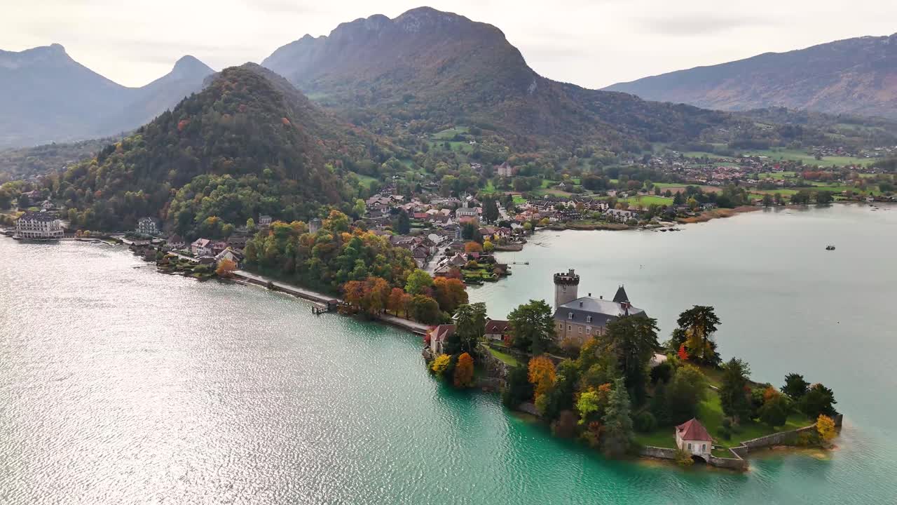 Château de Duingt on a wooded peninsula jutting into the western shore of Lake Annecy, just south of the village of Duingt, about 12 km from Annecy in Haute‑Savoie, eastern France, drone wide orbiting