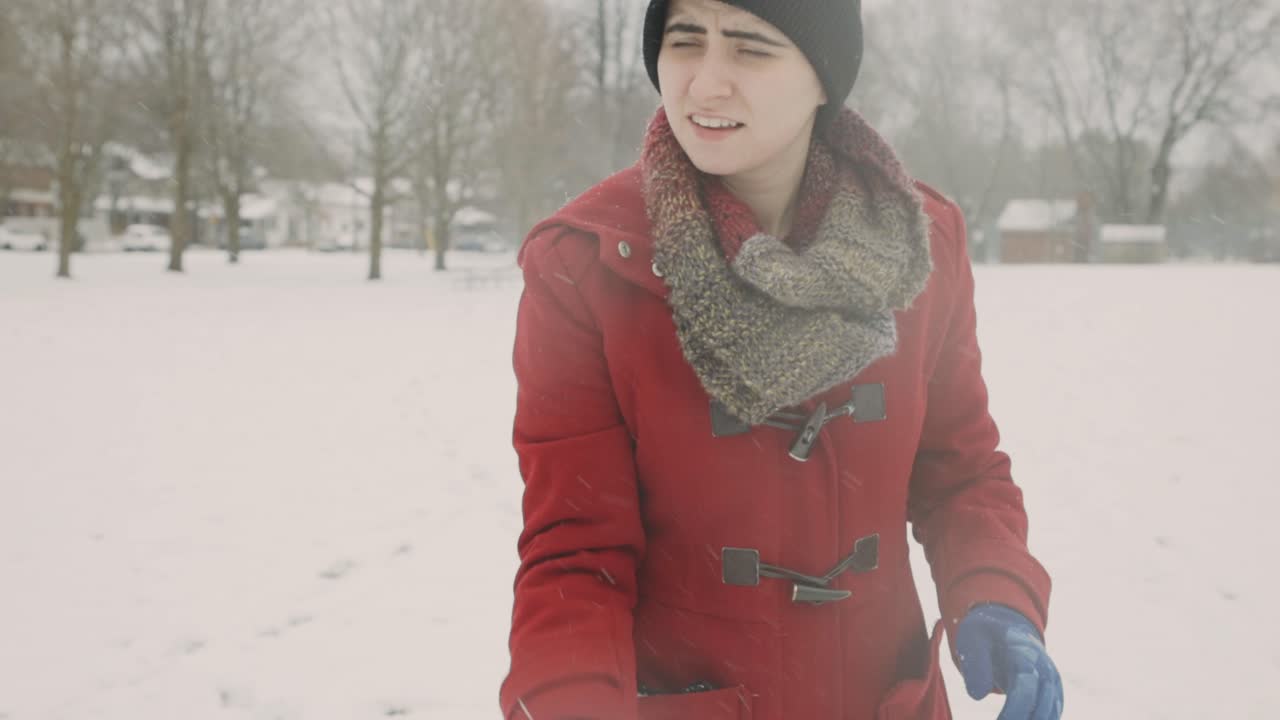 백인 여성은 추운 겨울날 눈덩이를 던지고 잡는다, 폭설 - 핸드헬드, 중간 샷