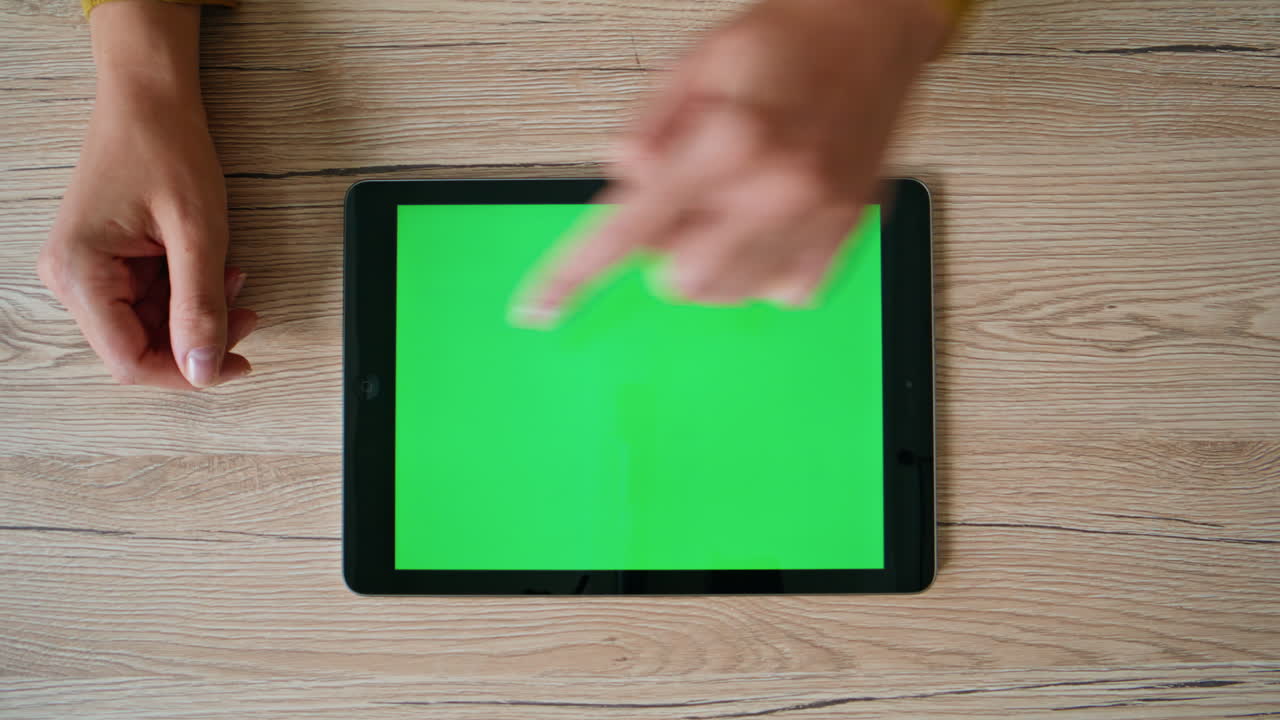 Employee hands swiping mockup tablet on desk closeup top view. Unknown woman