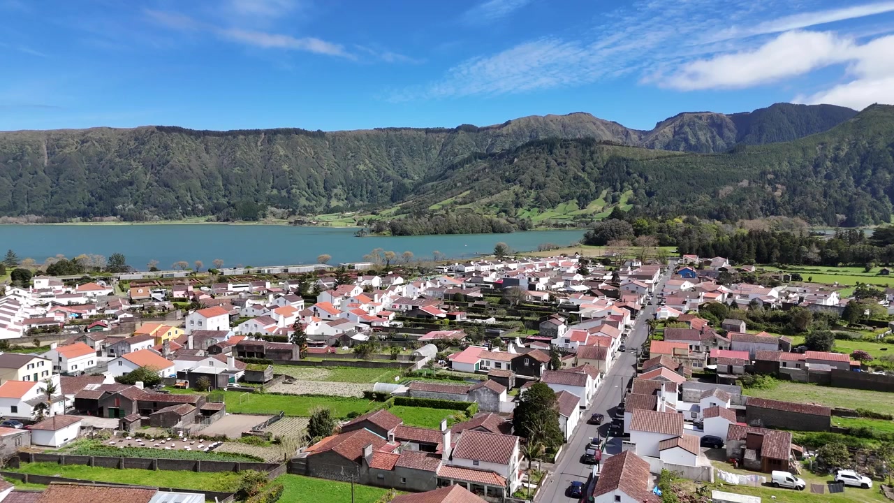Vista aerea da drone del villaggio di Sete Cidades e delle sue tradizionali case bianche. Paesaggio scenografico della valle vulcanica che si affaccia sui laghi gemelli sull'isola di São Miguel, Azzorre, Portogallo, Europa.