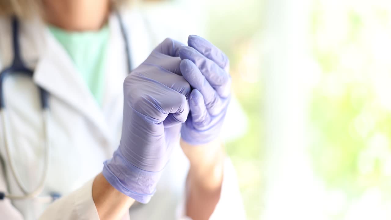 el médico se pone guantes médicos.