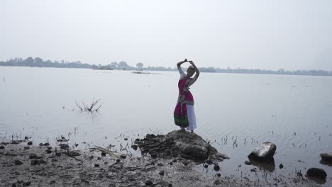 A-bharatnatyam-dancer-displaying-a-classical-bharatnatyam-pose-in-the-nature-of-Vadatalav-lake,-Pavagadh