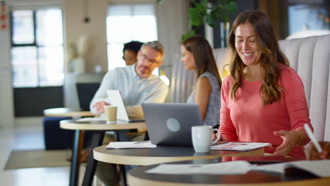 Mujer-De-Negocios-Madura-Haciendo-Videollamadas-En-Una-Computadora-Portátil-En-Una-Zona-De-Estar-Informal-De-Una-Oficina-Moderna