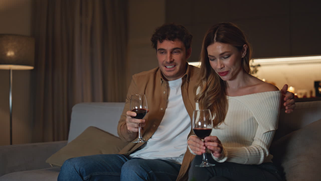 Giovane coppia al primo appuntamento in un appartamento romantico. Coppia felice seduta su un comodo divano.