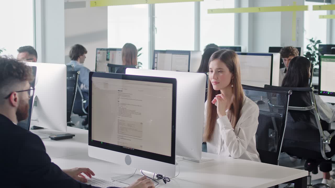 современный корпоративный офис с открытым пространством с буксирными рядами для бизнесменов и бизнесменов, работающих на настольных компьютерах.