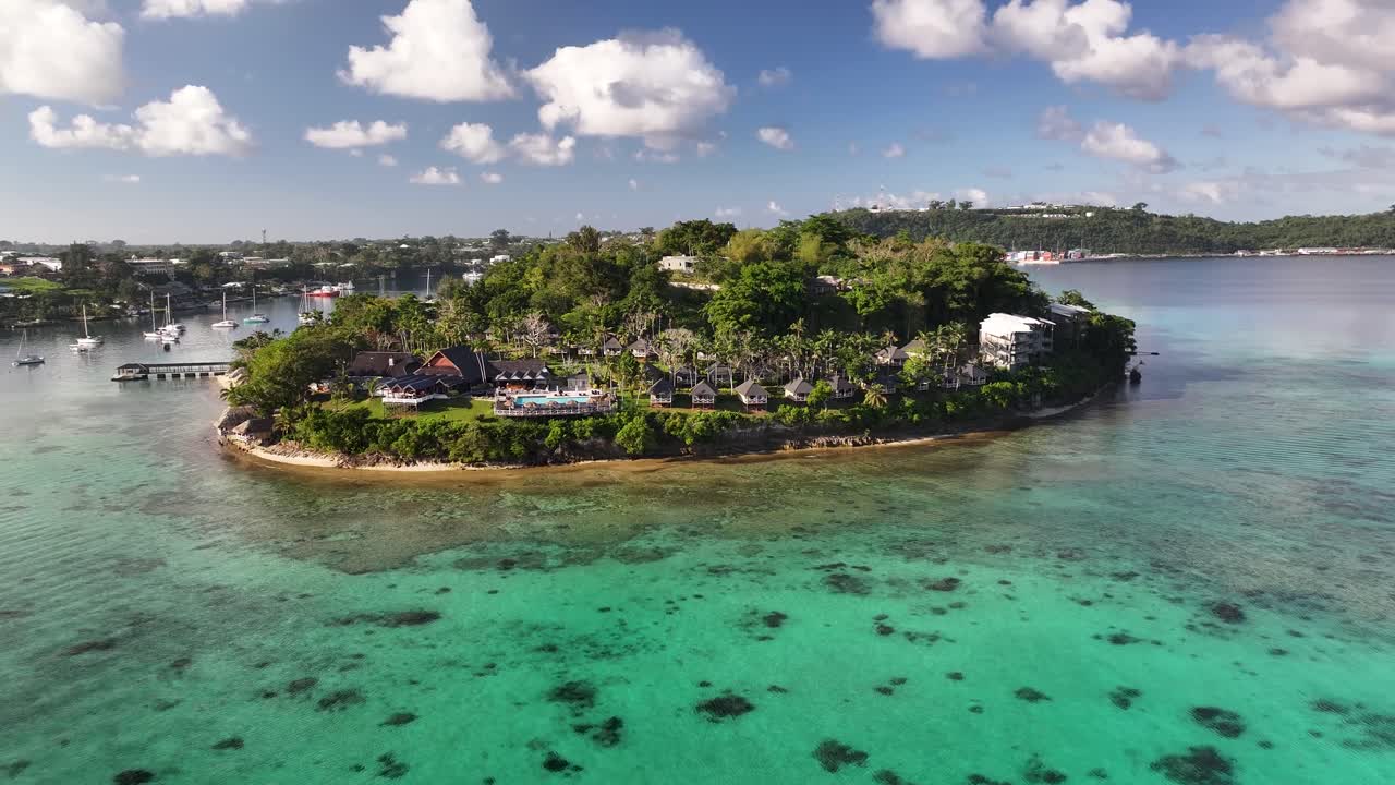 Tranquil Iririki Island, Vanuatu. Resort with hotel pool and bungalows with palm trees. Luxury vacation