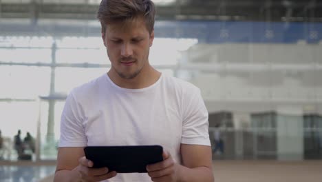 Smiling young man using digital tablet.