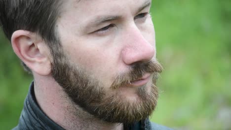 serious looking middle aged white man with beard looking to the right extreme close up