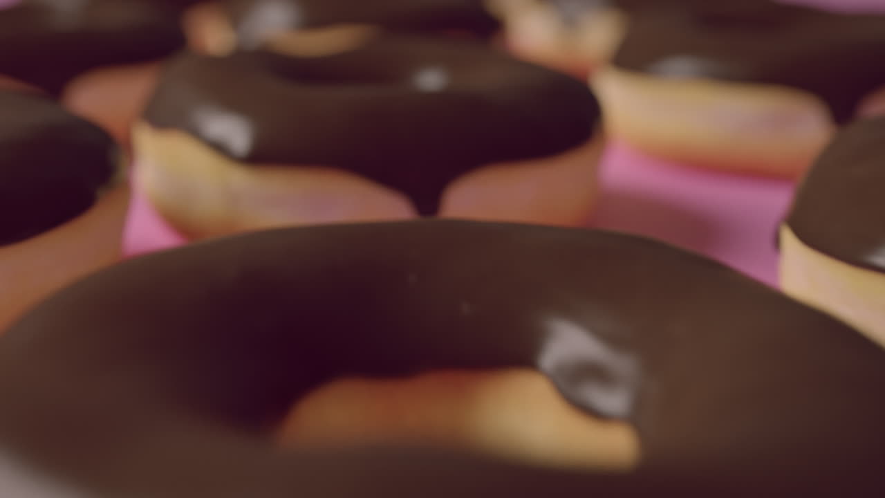Chocolate glaze donuts on a pink background