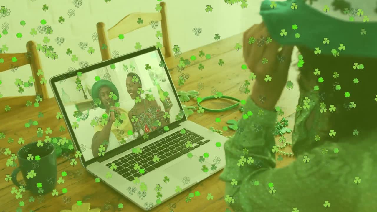 hojas de trébol cayendo contra la mujer que lleva gafas de trébol mientras tiene una videollamada en casa