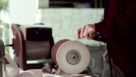 person sharpening a knife on a grinding wheel