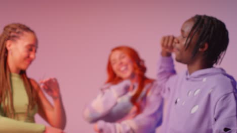 fotografía de estudio de jóvenes amigos de la generación z bailando en un club contra un fondo rosa 9