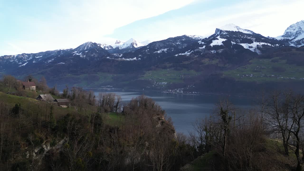 sobre el entorno natural de seerenbachfälle en weissen-amden, suiza, un lago sereno se anida en el fondo del valle, abrazado por montañas cubiertas de nieve en el fondo