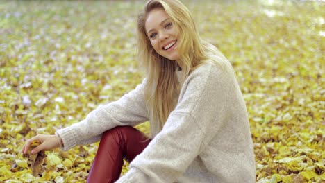 Cheerful-woman-sitting-on-ground