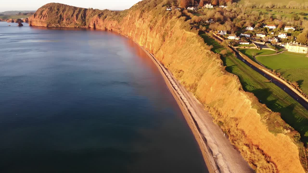 황금시간대에 해안선과 해변 옆에 있는 작은 마을의 드론 보기