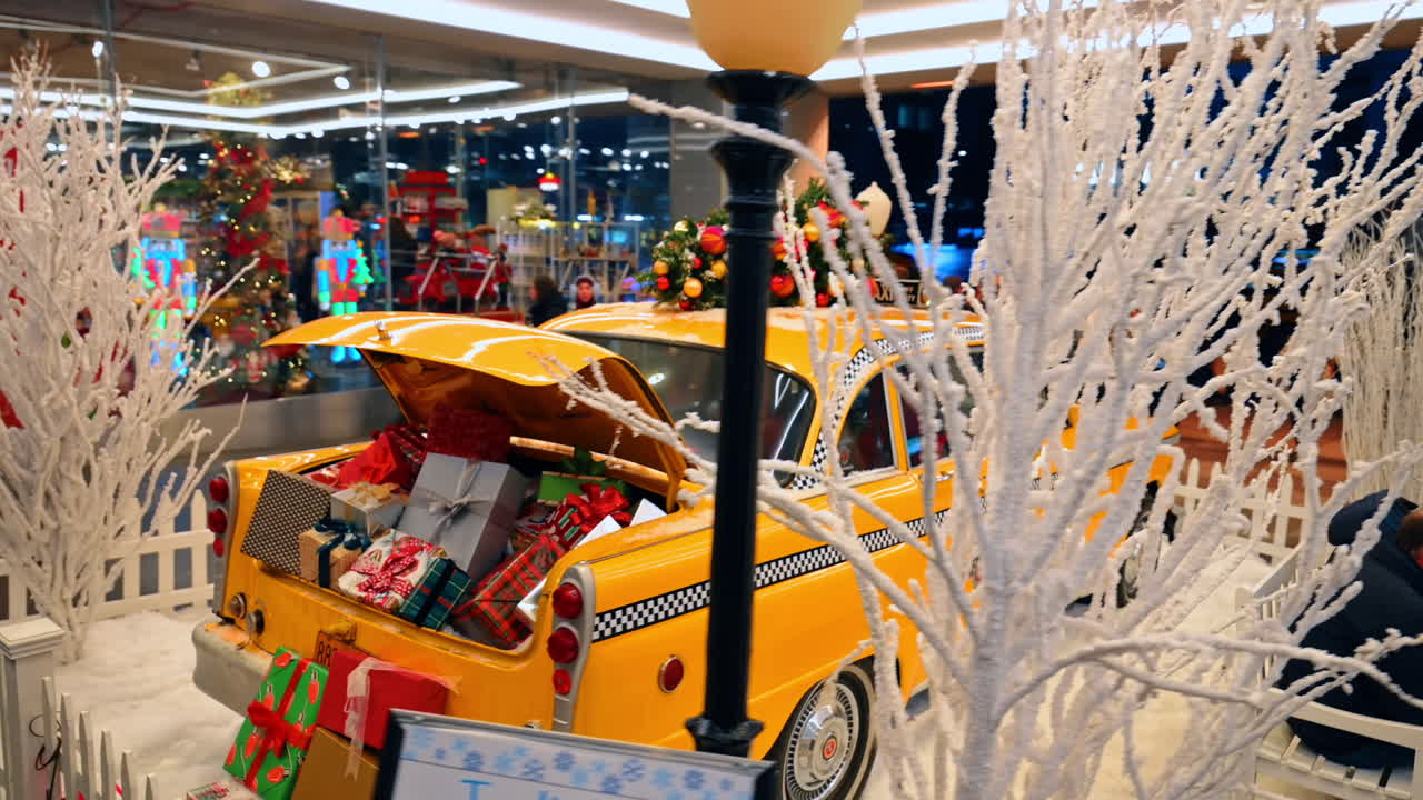 Nova York, EUA, 5 de dezembro de 2025: táxi amarelo vintage decorado para o Natal. Uma vista lateral de um táxi amarelo vintage, decorado com uma árvore de Natal e presentes, está montada em uma exibição de feriado nevado