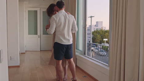 happy young couple dancing in hotel room enjoying successful vacation having fun celebrating on holiday