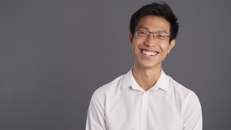 asian man laughing in front of the camera.