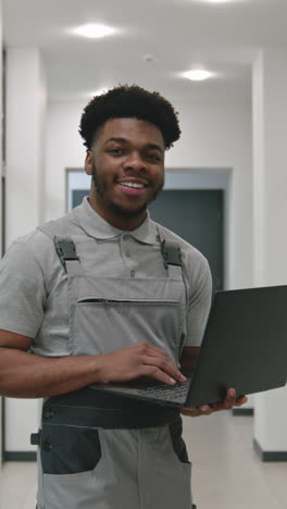 worker using laptop in office corridor