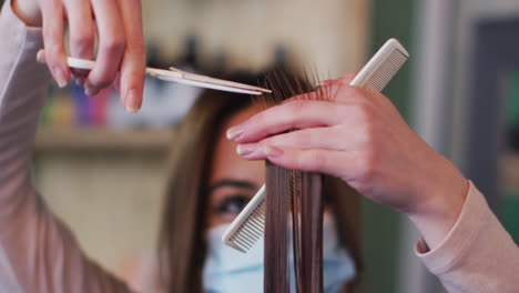 Friseurin-Mit-Gesichtsmaske-Schneidet-Einer-Kundin-Im-Friseursalon-Die-Haare