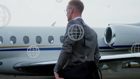 Animation-of-globe-icons-over-caucasian-businessman-walking