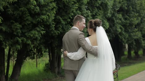 newlyweds. caucasian groom with bride walking in park. wedding couple. man and woman in love