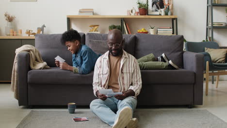 Man-and-boy-looking-at-pictures-at-home