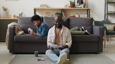 Man and boy looking at pictures at home