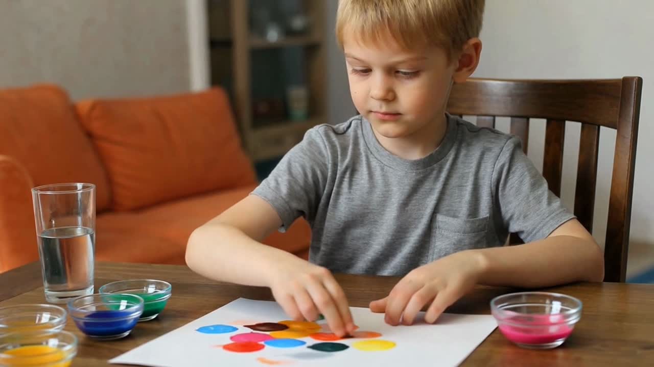 Young Boy Creating Colorful Dot Art with Finger Paints