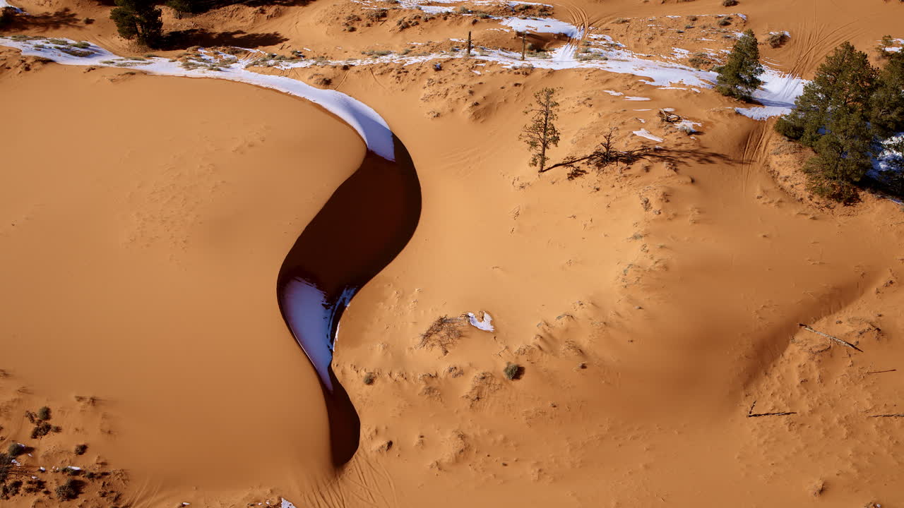The drone soars dramatically over the pink sand dunes, showcasing their rich colors and unique features.