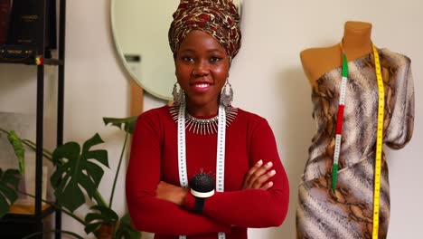 afro american woman with turban over head and silver ethnic colorful jewelry in tailor workshop