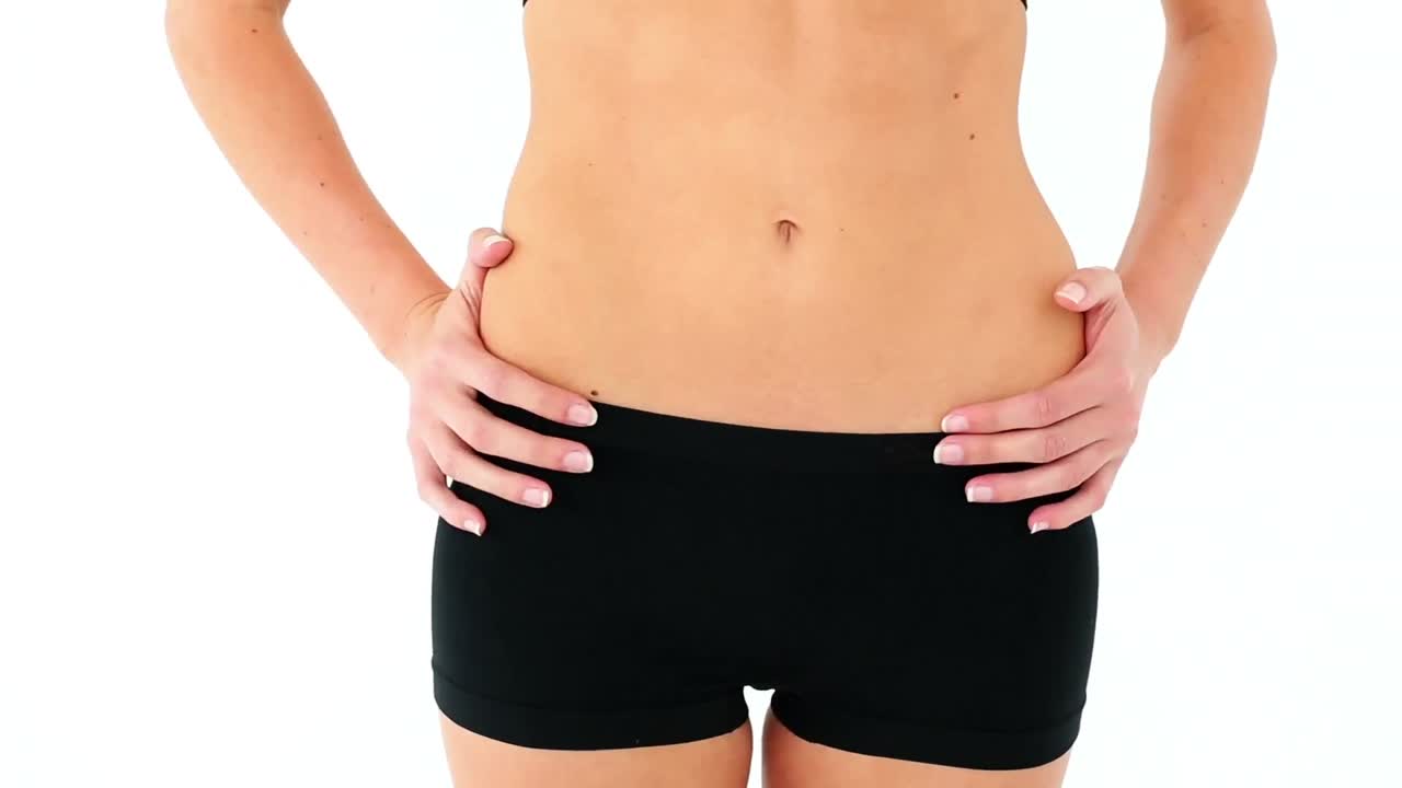 Fit model in sports bra touching her stomach