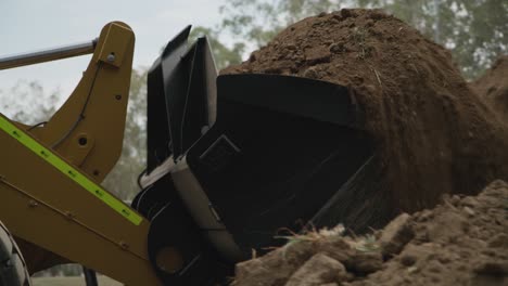 video agrícola que muestra una máquina pesada de movimiento de tierras recogiendo tierra