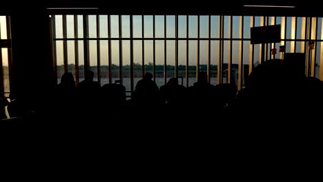 Gente-Esperando-Para-Abordar-El-Avión-En-El-Aeropuerto---Vista-De-Silueta-Al-Atardecer