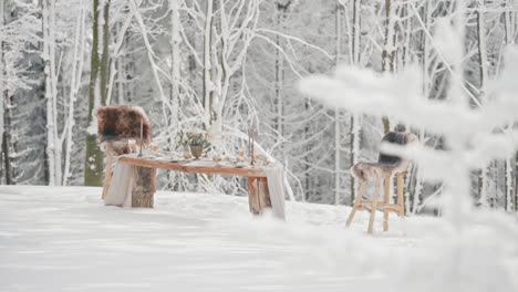 wedding editorial setting, decorated table with two chairs in snowy winter forest