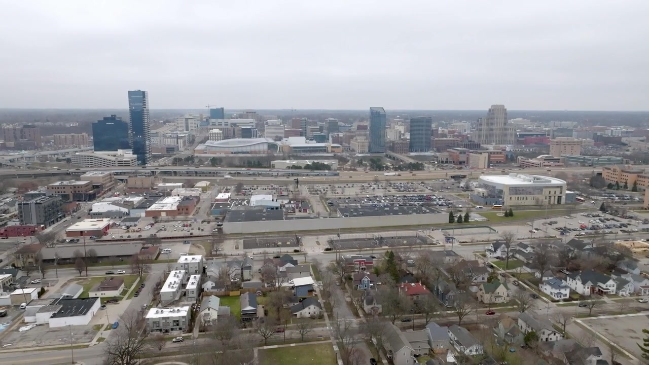 Neighborhood in Grand Rapids, Michigan and wide shot of Grand Rapids skyline with drone video pulling back and up.