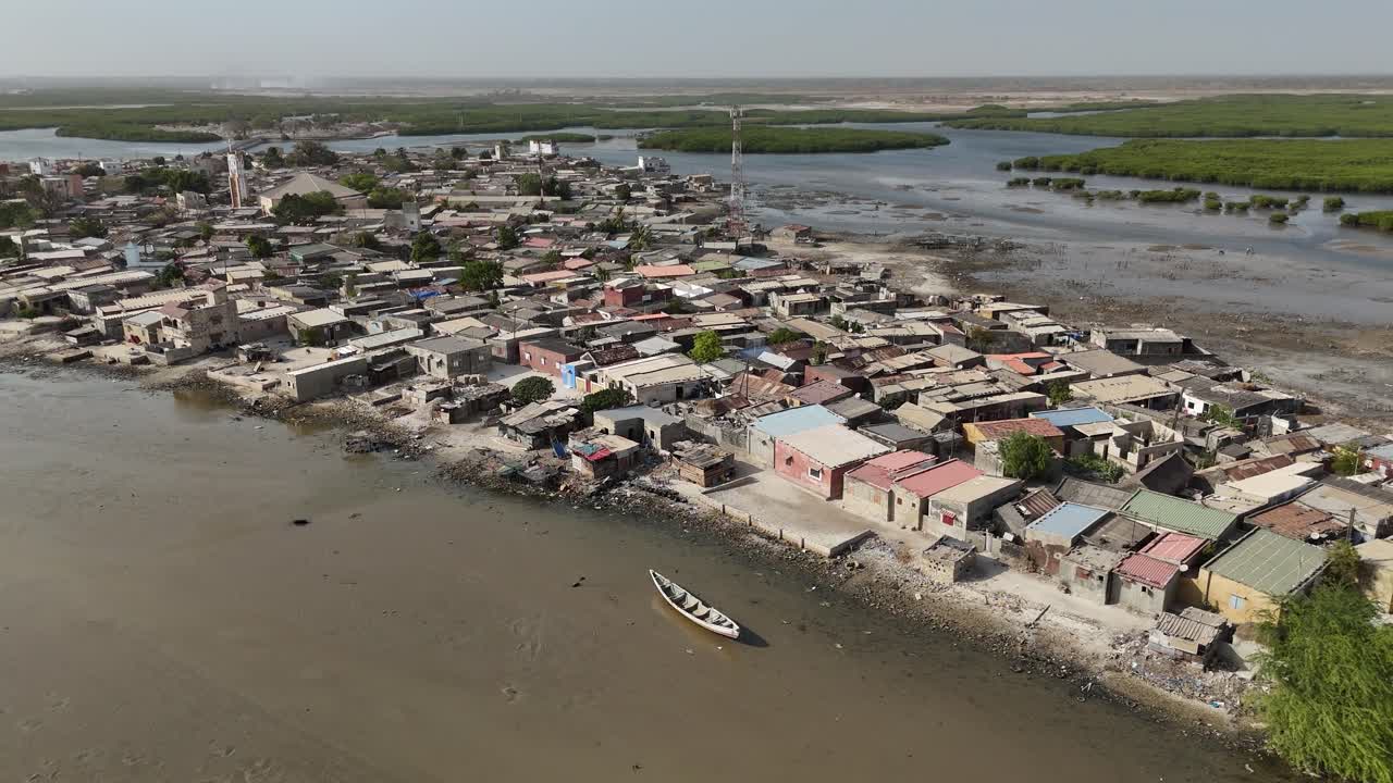 Aerial drone of Joal Fadiouth village in Senegal along the coast, showing houses, shoreline and fishing community lifestyle in West Africa