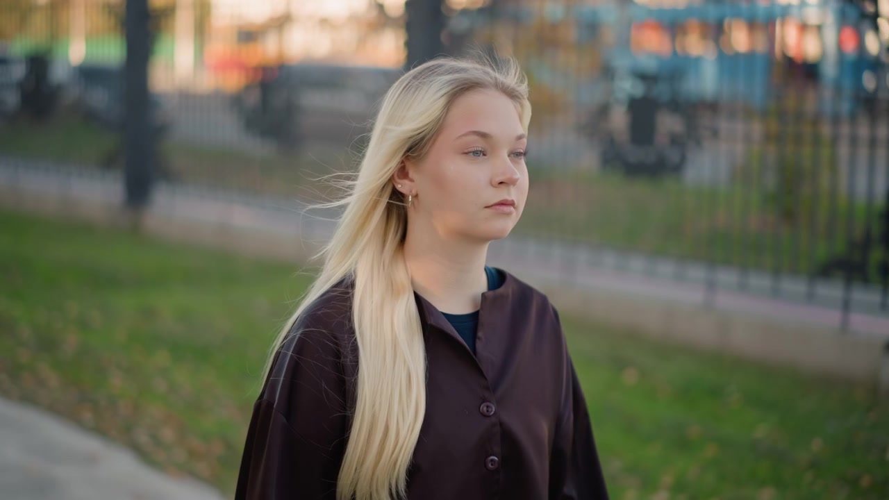 Young Blonde Woman Standing Outdoors in Urban Setting