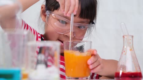 children are learning and doing science experiments in the classroom. two little sisters playing science experiment for home schooling. easy and fun science experiments for kids at home.