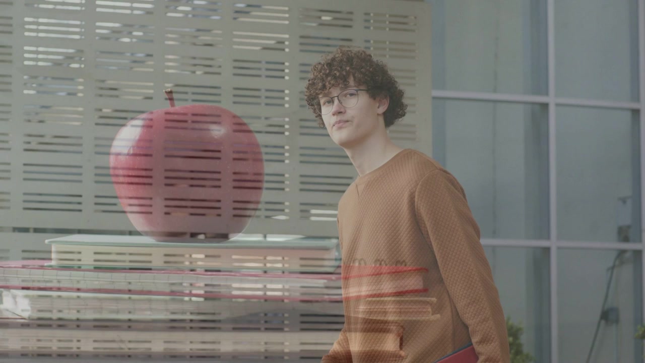 Homem caminhando, desviando o olhar do telefone, virando-se para uma vitrine de maçãs vermelhas, buscando uma visão mais próxima.