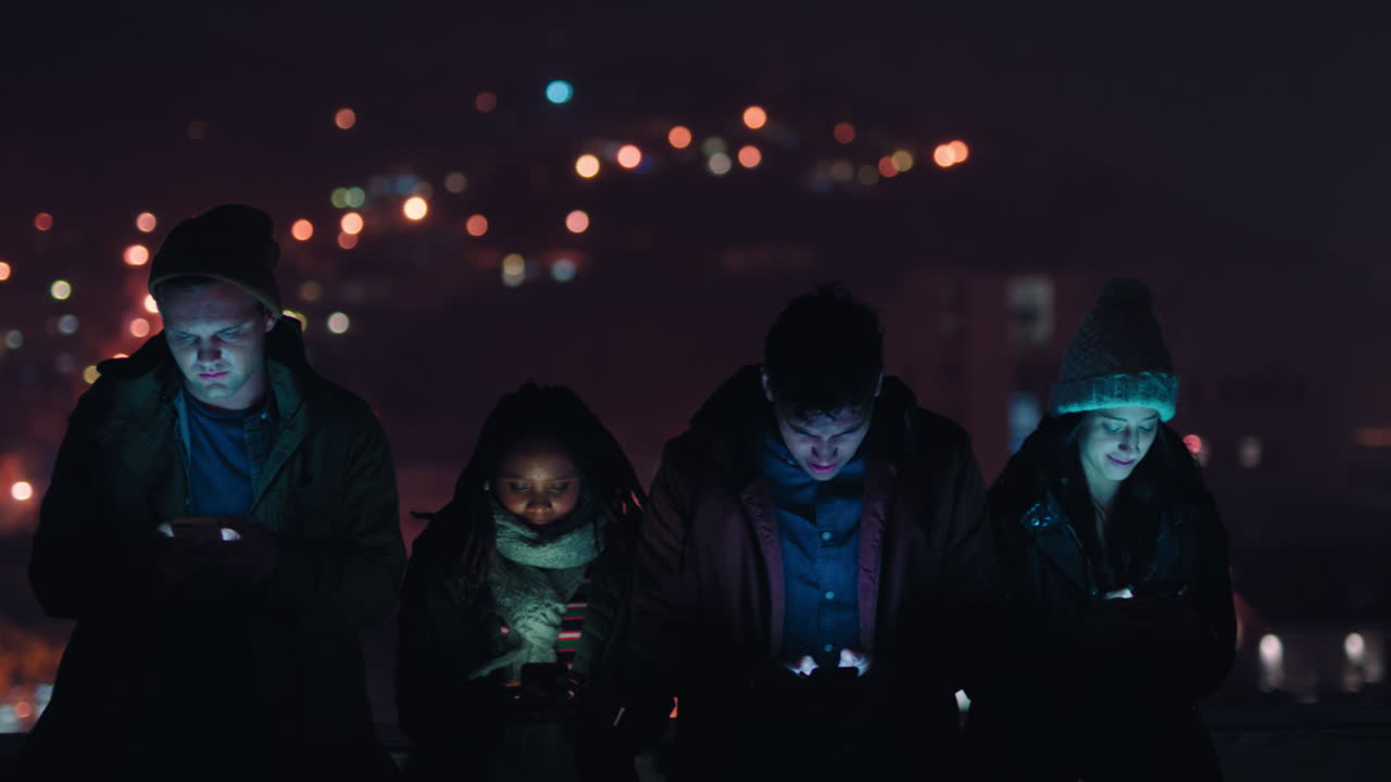 grupo de amigos relajándose en la azotea por la noche usando tecnología de teléfonos inteligentes navegando por las redes sociales chateando en línea disfrutando de una reunión de fin de semana